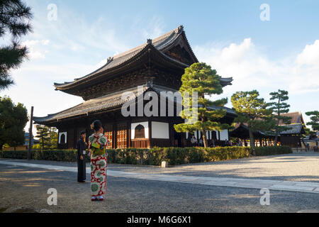 Un giovane giapponese giovane vestito di kimono, prendendo una foto a un tempio a Kyoto, Giappone Foto Stock