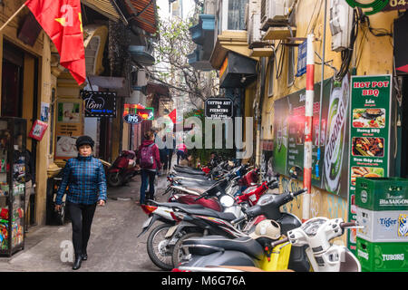 Scooter parcheggiate lungo una strada stretta ad Hanoi, Vietnam Foto Stock