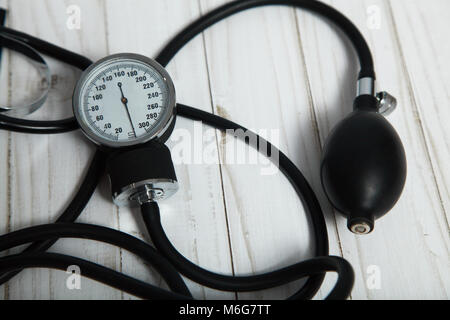 Dispositivo portatile per la misura della pressione del sangue su un sfondo di legno. Foto Stock