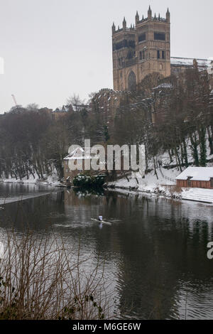 Lone rower sul fiume indossare di fronte la Cattedrale di Durham con il tardo inverno Neve Foto Stock