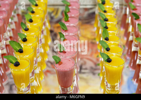 Catring colorati mousse di frutta dolce in vetro su specchio sfondi Foto Stock