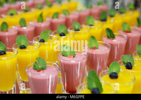 Catring colorati mousse di frutta dolce in vetro su specchio sfondi Foto Stock