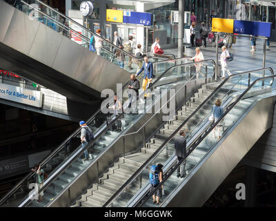 I viaggiatori a Berlino la stazione ferroviaria principale di Hauptbahnhof prendere le scale mobili a livello di piattaforma. Berlino stazione centrale è il più grande in Europa Foto Stock