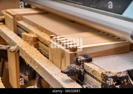 Giunto a coda di rondine. Lavorazione del legno e produzione di carpenteria. Parte di un cassetto in legno realizzato con una fresatrice. Primo piano Foto Stock