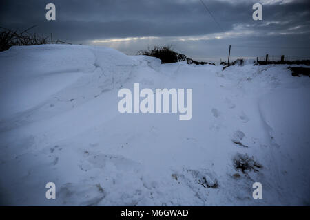 After Effects di tempesta Emma è visto nel borgo marinaro di Abersoch, con pesanti derive di neve, vento, neve sulla spiaggia e un porto congelati. Foto Stock