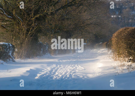 Neve profonda su un vicolo del paese nella campagna inglese. Foto Stock