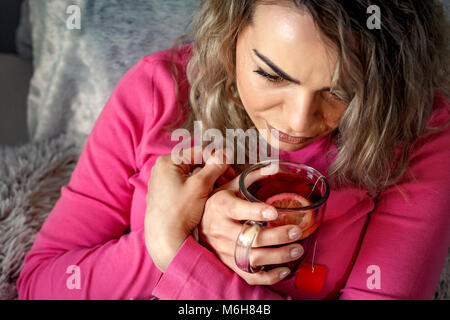 Vista superiore del malato giovane donna bere il tè e giacente in letto Foto Stock