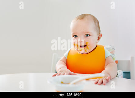 Bambino seduto a pranzare tabella e sorridente Foto Stock