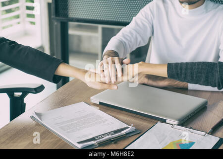 Tre business partners team con le mani insieme al saluto avviare il progetto in ufficio. Incontro di lavoro concept Foto Stock