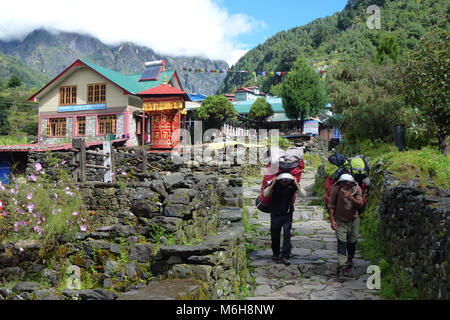 Foto di oa ruota di preghiera con facchini in Phakding, Campo Base Everest trek, Nepal Foto Stock