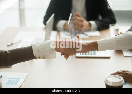 Handshaking imprenditrici alla riunione del gruppo di alimentazione delle donne in busin Foto Stock