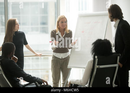 Femmina di team leader o business coach dando la presentazione a empl Foto Stock