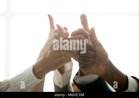 Multirazziale team aziendale le mani che mostra Thumbs up, vista ravvicinata Foto Stock