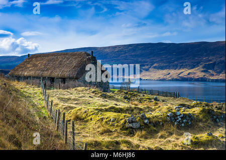 Un tradizionale Blackhouse vicino a Uig, Isola di Skye, con le rovine del vecchio edificio in primo piano. Foto Stock