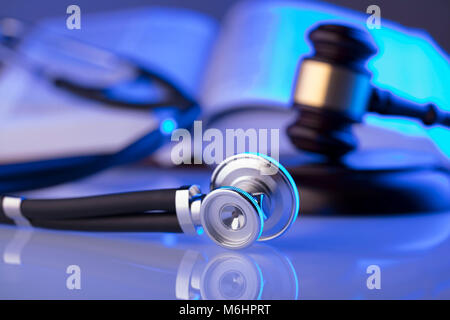 La legge medica concetto. Martello, uno stetoscopio luce blu. Luogo fort testo. Foto Stock