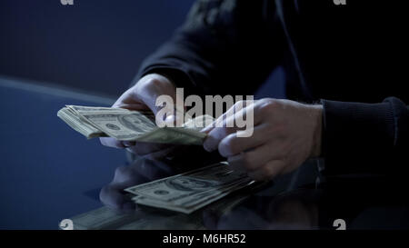 Maschio conteggio mani di dollari, nero lo stipendio, il riciclaggio di denaro, business illegale Foto Stock