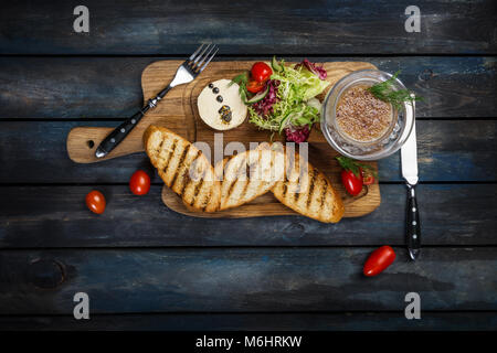 Toast con burro e caviale servito con posate su un sfondo di legno Foto Stock