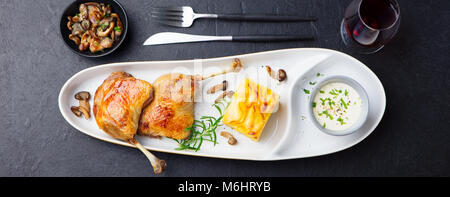 Gambe di Anatra confit con patate gratinate e salsa di funghi. Il ristorante serve. Vista dall'alto. Foto Stock