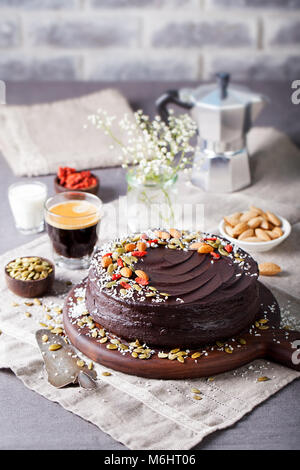 Vegano barbabietole al cioccolato torta con glassa di avocado, decorate con noci e semi. Spazio di copia Foto Stock