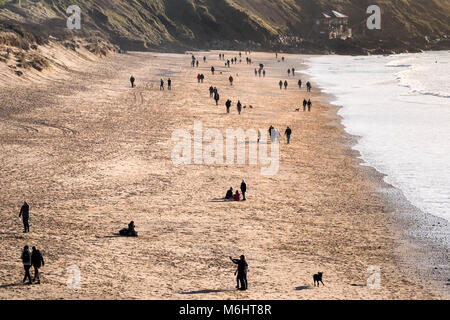 La gente camminare lungo Fistral Beach in prima serata la luce solare Newquay Cornwall. Foto Stock