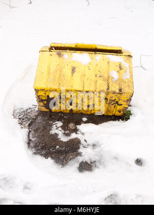 Caduto ribaltato giallo casella di grana sale al di fuori della tempesta di neve; essex; Inghilterra; Regno Unito Foto Stock