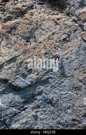 23 luglio 2014; UN arrampicatore femminile scende lungo la parete rocciosa dei laghi grassi vicino a Canmore, Alberta, Canada Foto Stock