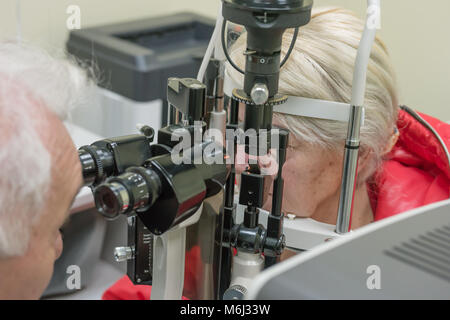 Di Zrenjanin, Serbia, Febbraio 2018: ottico esaminando donna anziana occhi attraverso la lampada a fessura in clinica. Foto Stock