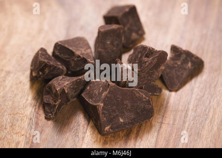 Cioccolato fondente pezzi sul tavolo di legno Foto Stock