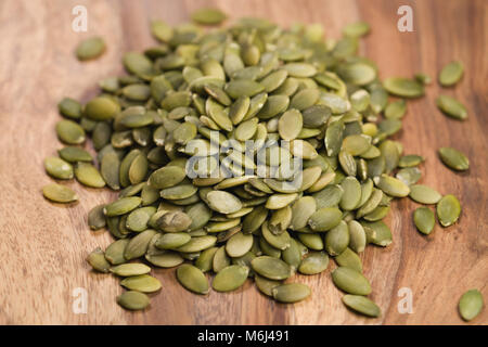 Verde semi di zucca sul tavolo di legno Foto Stock