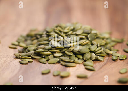 Verde semi di zucca sul tavolo di legno Foto Stock