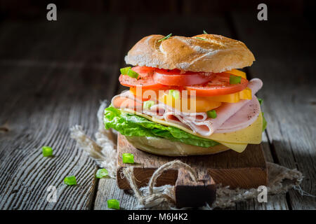 Un sano panino con pomodoro, formaggio e prosciutto Foto Stock