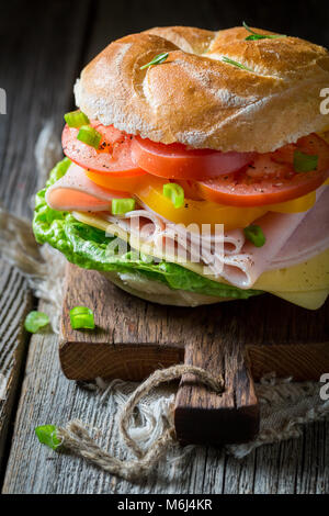 Grande panino con pomodoro, formaggio e prosciutto Foto Stock