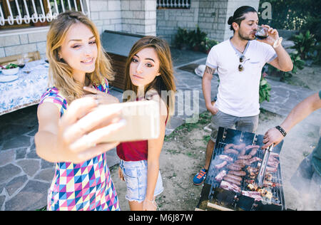 Gruppo di amici fare barbecue nel cortile. concetto circa il bene e stato d'animo positivo con gli amici Foto Stock