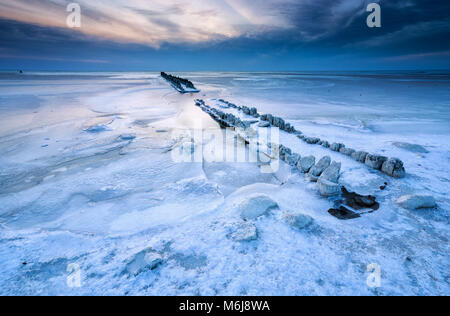 Struttura di frangionde congelate in ghiaccio sul lago Ijsselmeer, Paesi Bassi Foto Stock