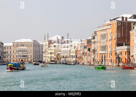 Occupato il traffico delle barche di fronte coperta di neve di palazzi sul Canal Grande, San Polo, Venezia, Veneto, Italia durante il rigido inverno con Si Foto Stock