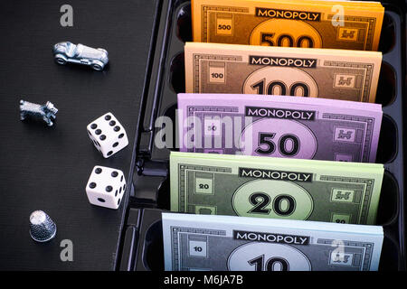 Tambov, Federazione Russa - 26 gennaio 2018 monopolio Board Game Box con pacchi di denaro, token e dadi. Foto Stock