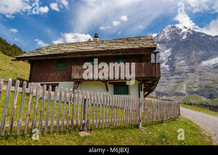 Vecchia casa tradizionale nelle Alpi Bernesi, montagna monch in background in estate. Lauterbrunnen, regione di Jungfrau, Oberland bernese, Svizzera Foto Stock