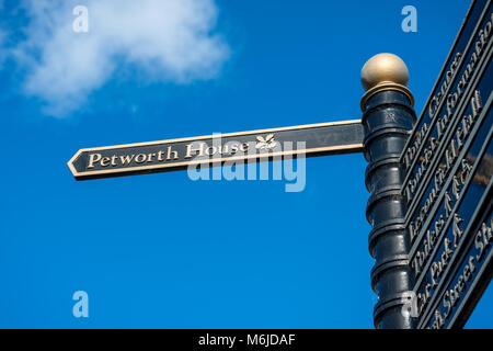 Petworth, West Sussex, in Inghilterra. Un cartello stradale che indica il percorso a Petworth House nella piccola cittadina. Foto Stock