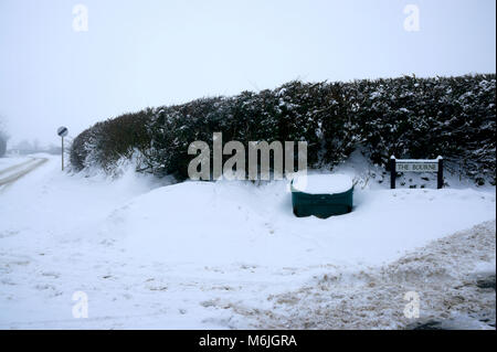 Scomparto di sale sul bordo della strada attraverso il villaggio colpito con neve pesante a seguito tempesta Emma & la Bestia da est Foto Stock