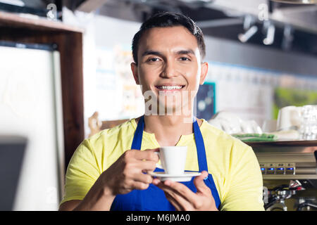 Barista in Indian cafe coppa di ritegno Foto Stock