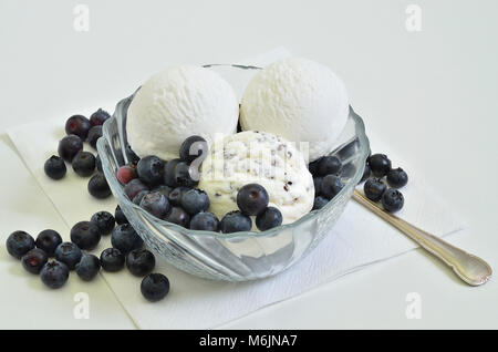 Gelato alla vaniglia e Stracciatella Gelato con i mirtilli in una ciotola su sfondo bianco, vicino, frame completo Foto Stock