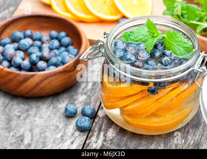 In casa bevanda a base di frutta con frutti di bosco arance e menta Foto Stock