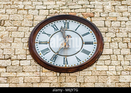 Antico orologio sul campanile di pietra del Tempio di Minerva, iconico punto di riferimento in Assisi, Italia Foto Stock