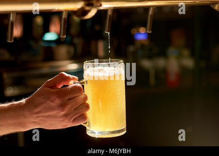 Barista versando fresca birra nei pub. Foto Stock