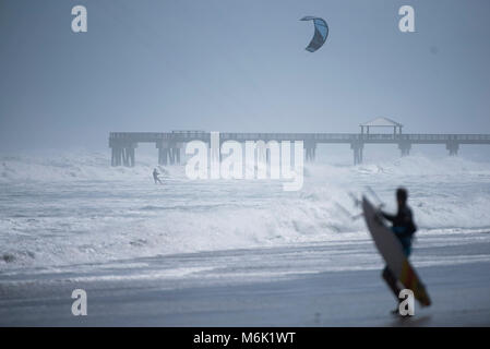 Jupiter, Florida, Stati Uniti d'America. Mar 4, 2018. Un kite surfer osserva un altro kite surfer ride vicino alla spiaggia di Juno Pier in Giove, Fla., domenica 4 marzo 2018. Venti forti da un potente né'pasqua generata ad alta si rigonfia e discontinuo acqua al largo di Palm Beach County. Il servizio meteorologico nazionale con le previsioni che le onde si potrebbe costruire a 15 piedi. Credito: Andres Leiva/Palm Beach post/ZUMA filo/Alamy Live News Foto Stock