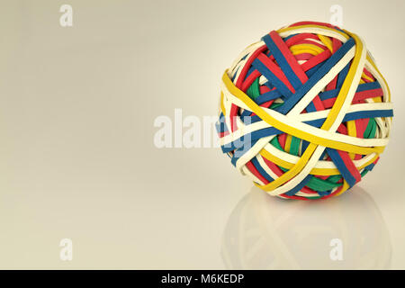 La banda di gomma una sfera realizzata da molte colorate bande elastiche isolato su uno sfondo bianco Foto Stock