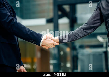 Due multirazziale handshaking gli imprenditori in un ufficio moderno per la fine della grande Foto Stock