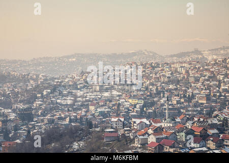 Vista aerea delle colline della periferia di Sarajevo, Bosnia ed Erzegovina durante un inverno freddo pomeriggio di neve che ricoprono tutto. Una moschea può essere s Foto Stock