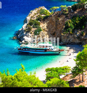 Bellissima spiaggia di Apella,vista con un mare azzurro e barca,Karpathos isola,Grecia. Foto Stock