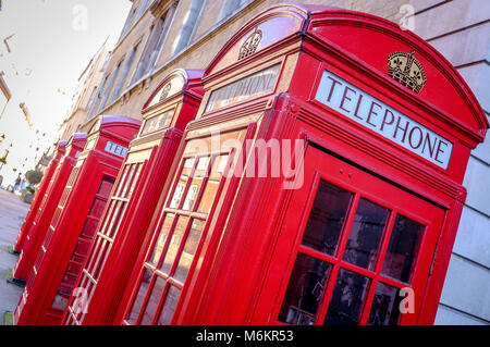 Una fila di 5 iconico British telefono rosso le caselle in una strada di Londra Foto Stock